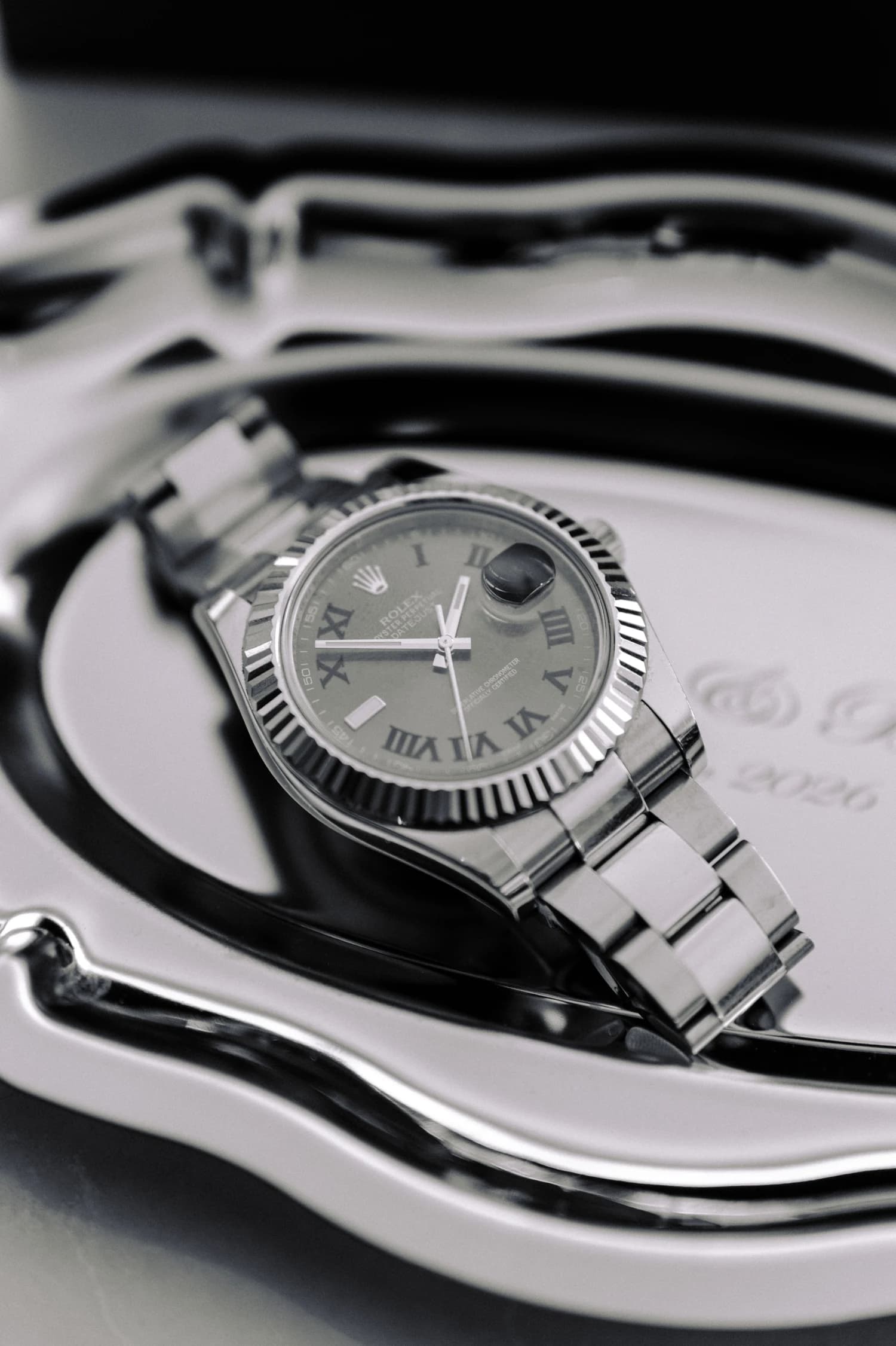 A wristwatch resting on a silver tray in the dressing room.