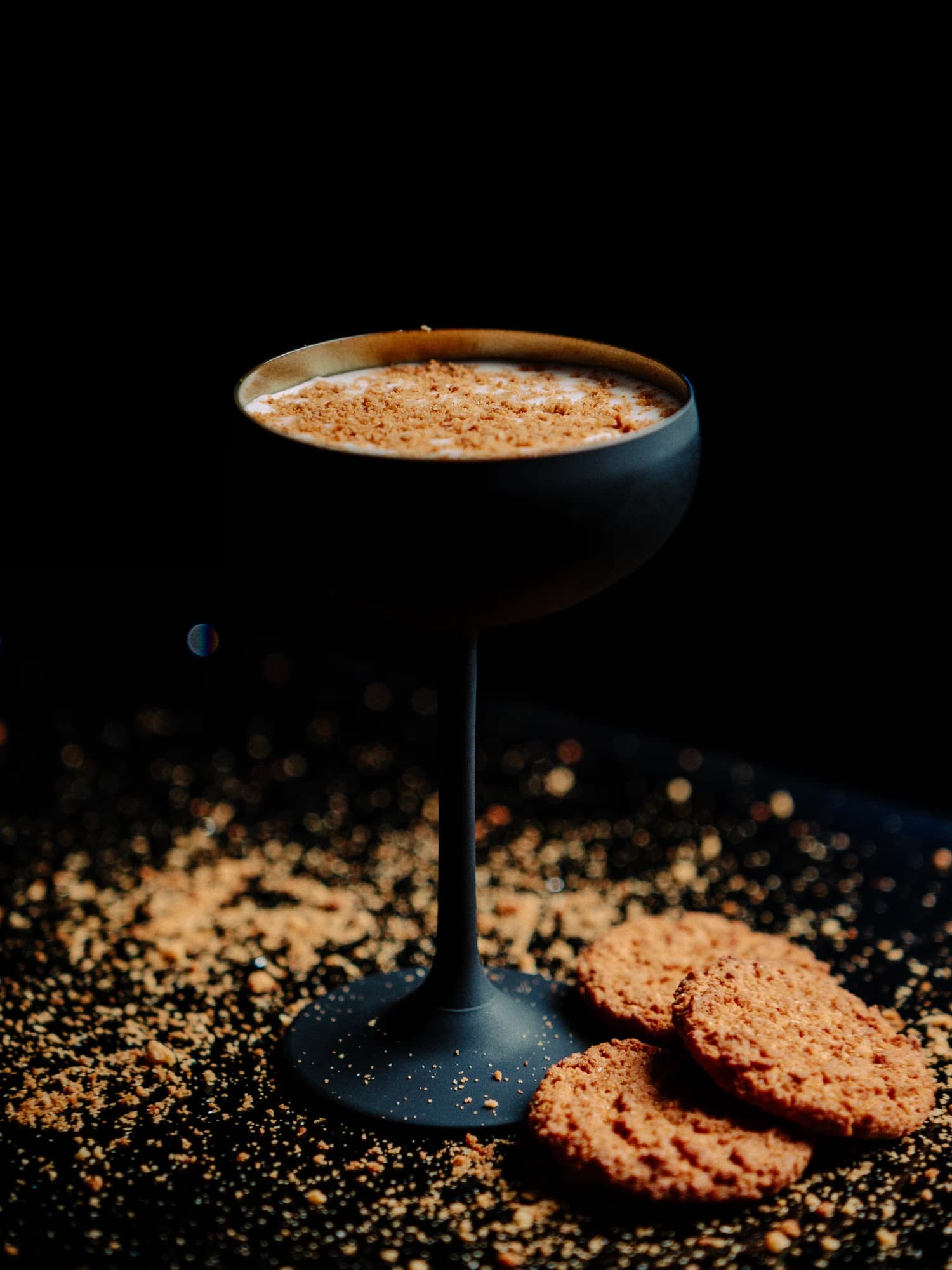 A butterscotch cocktail in a stemmed glass with a biscuit crumb garnish at Circa 1884.