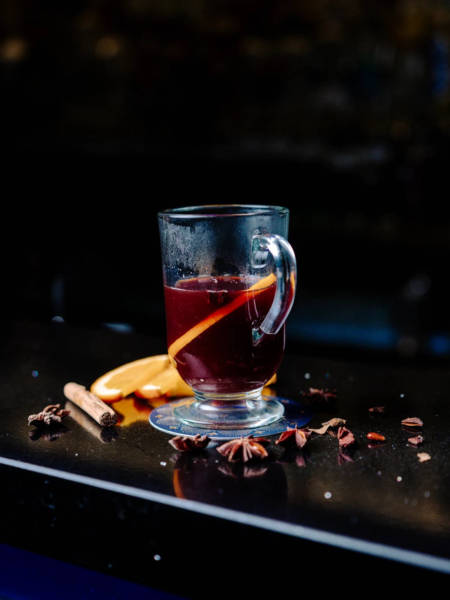 A glass of mulled wine beside citrus, star anise and spices at Circa 1884.