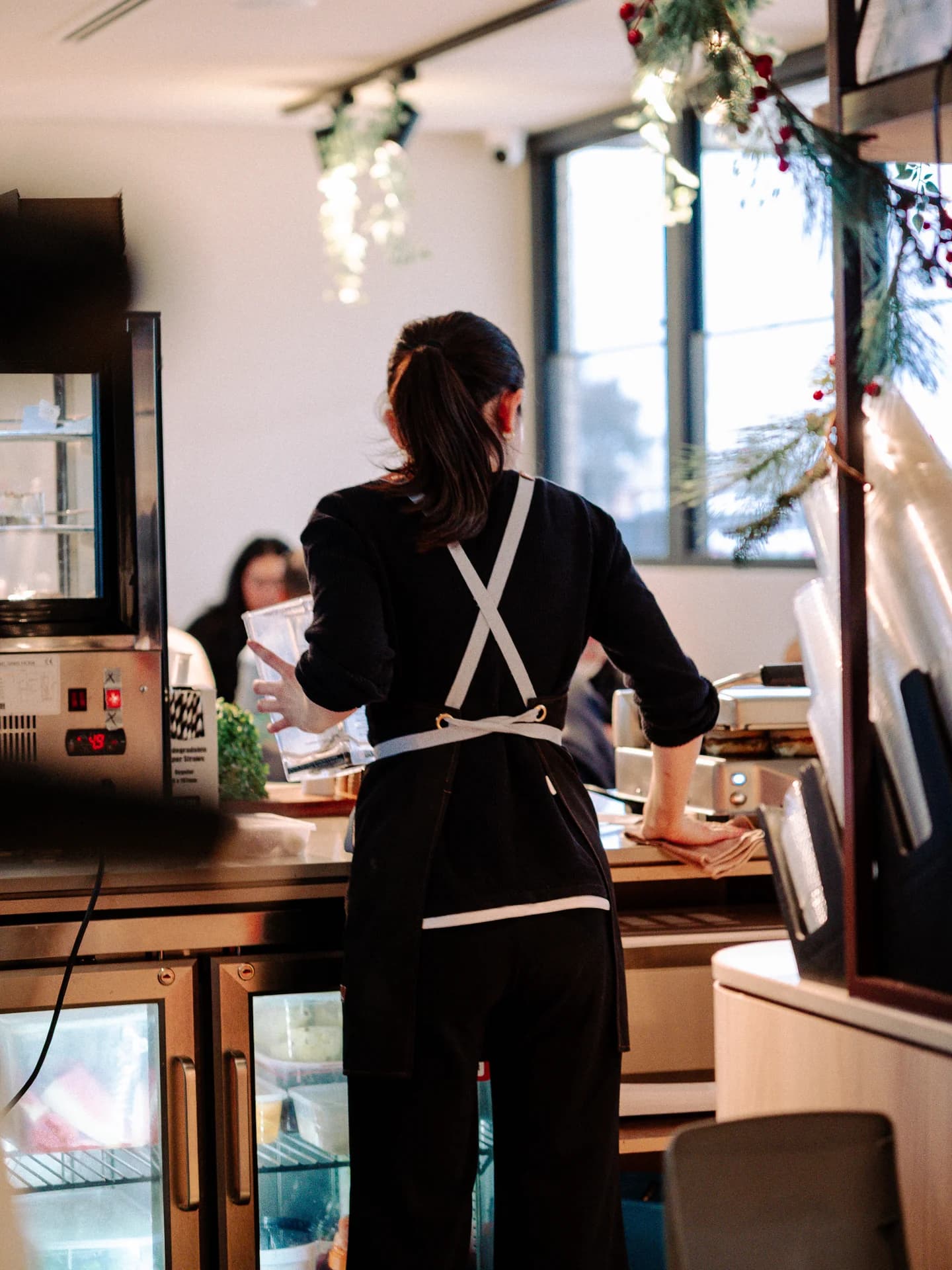 A Five Farms Cafe team member working behind the coffee counter in Clyde North