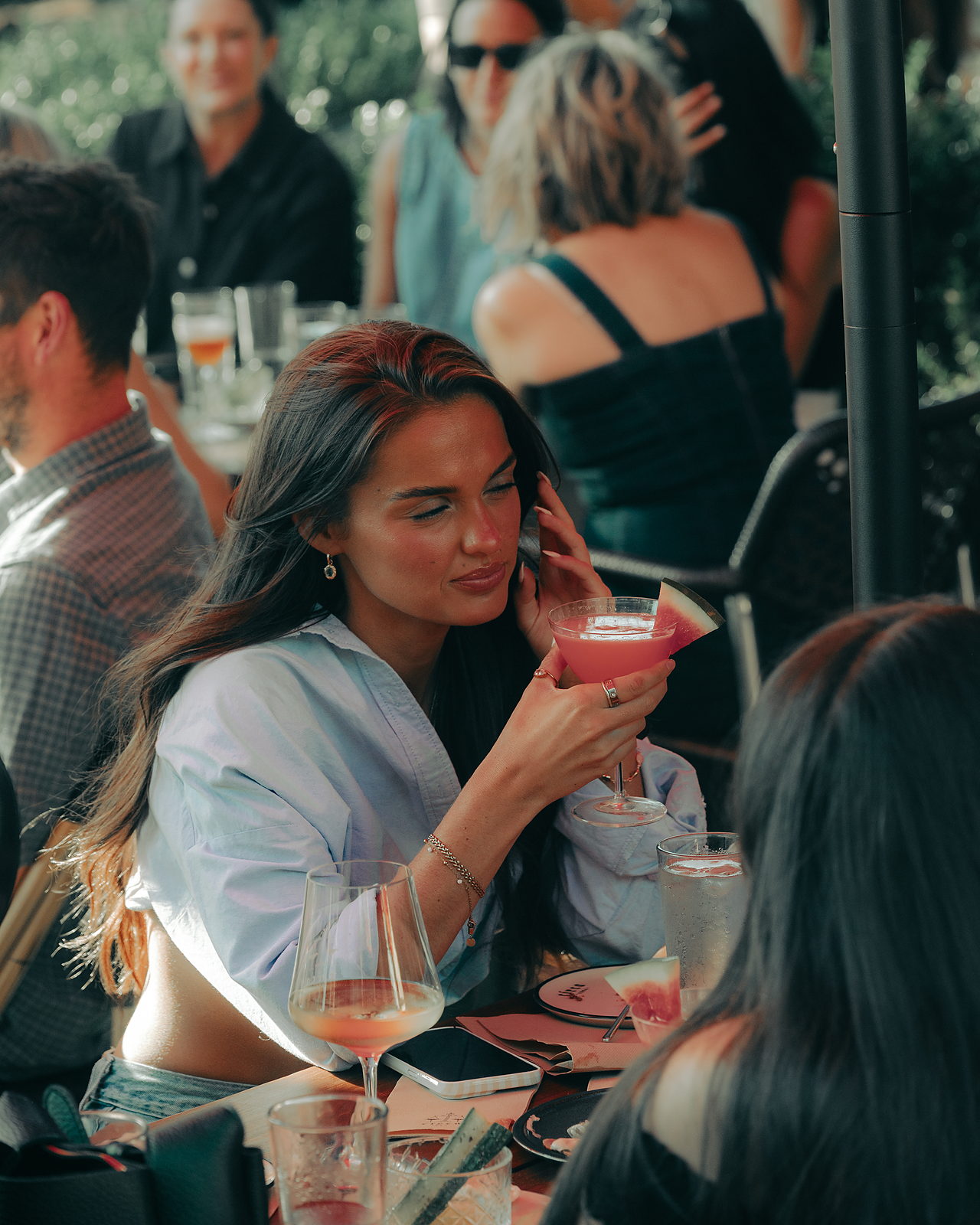 Guests holding drinks around a table on Circa 1884’s terrace.
