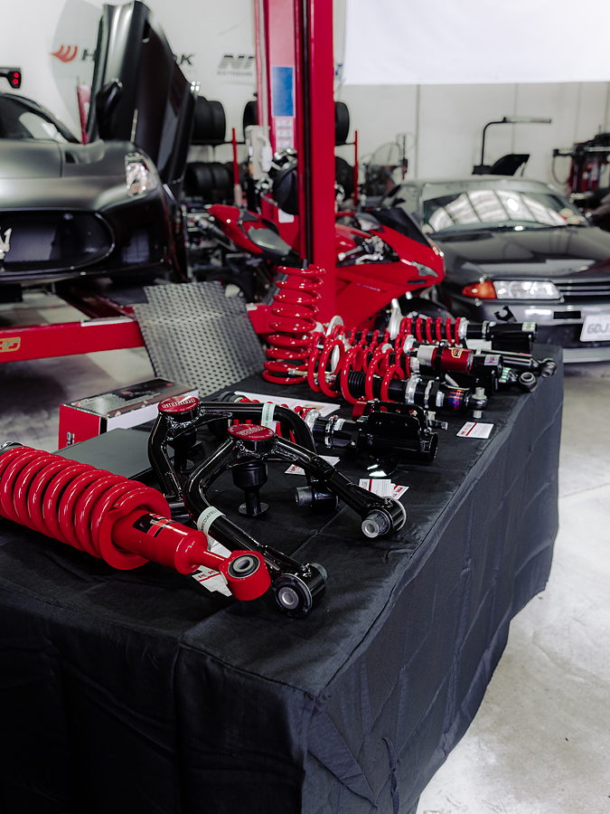 Red and black suspension components displayed on a table inside the DHF Tyres workshop.