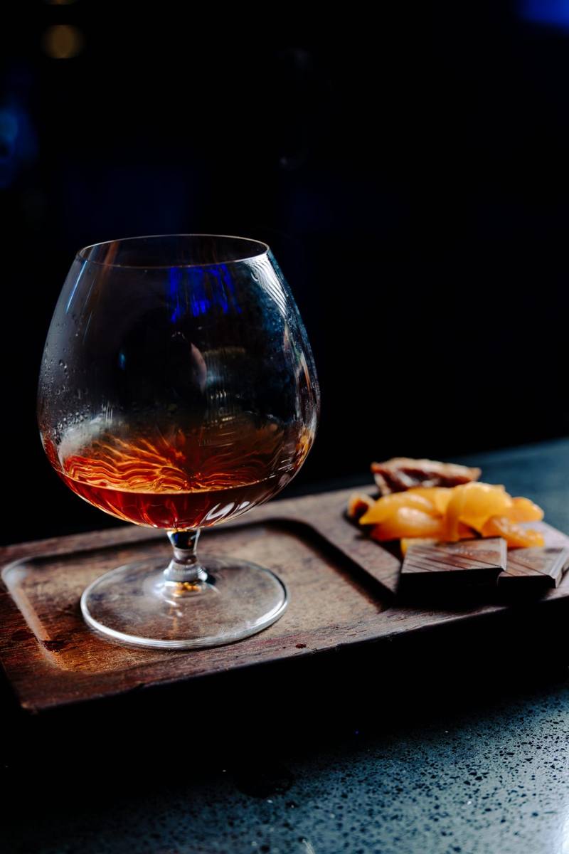 Circa 1884 — brandy snifter with dried fruit and chocolate board