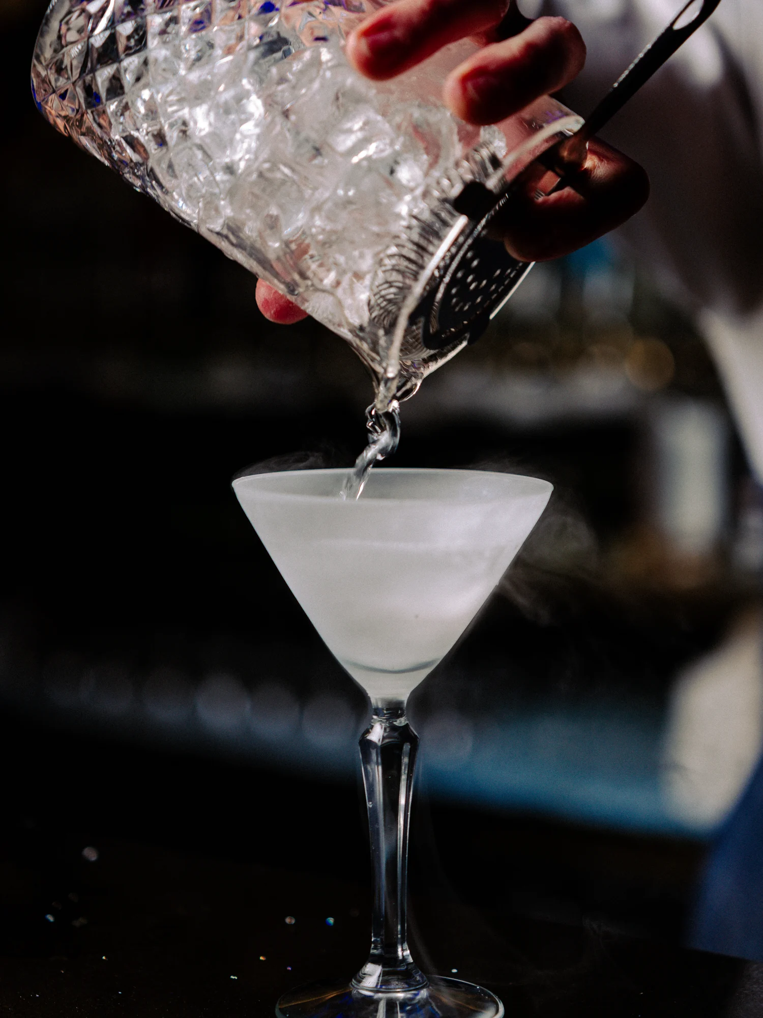 A cocktail being poured into a martini glass at Circa 1884