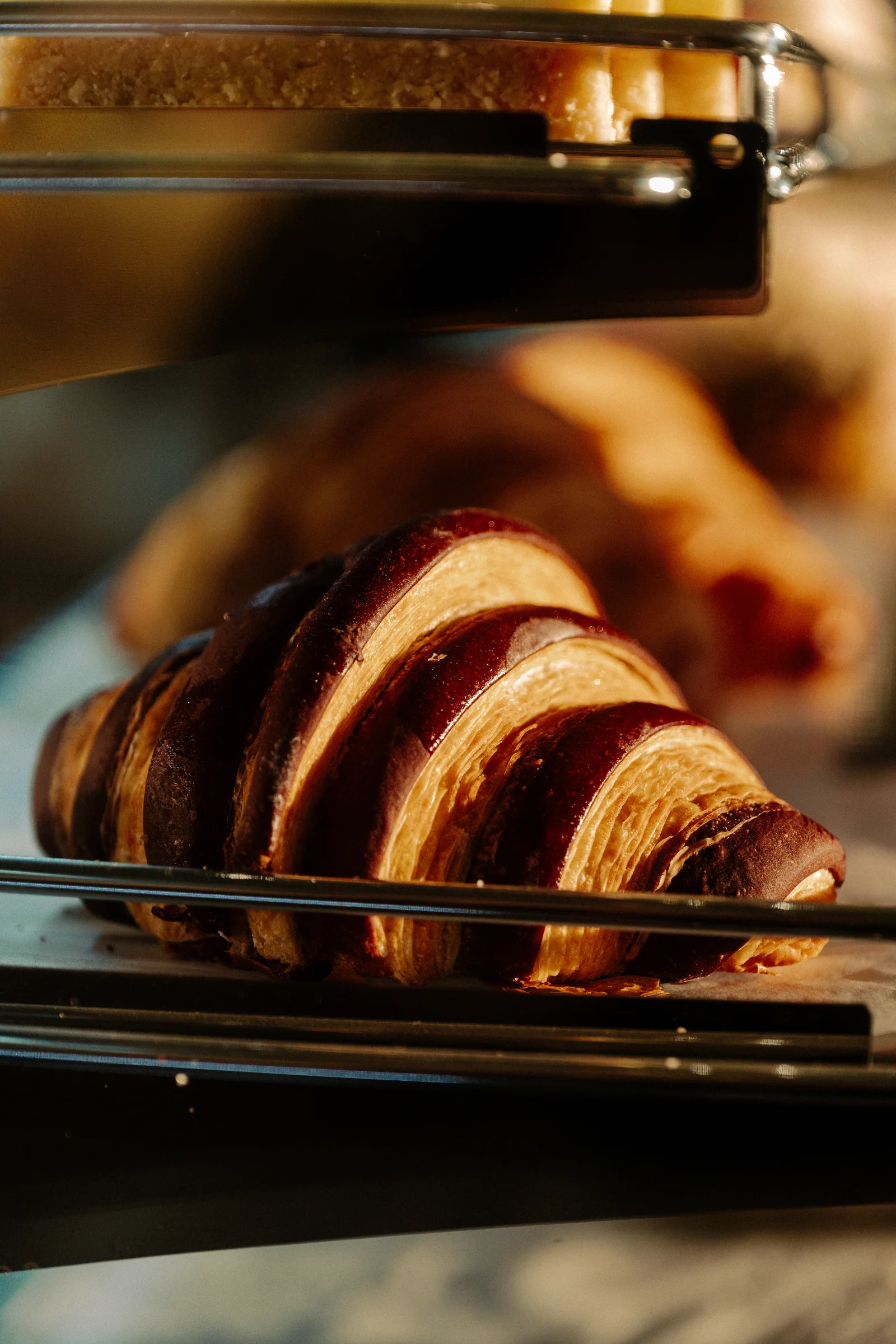 A striped croissant on a rack in the cafe display