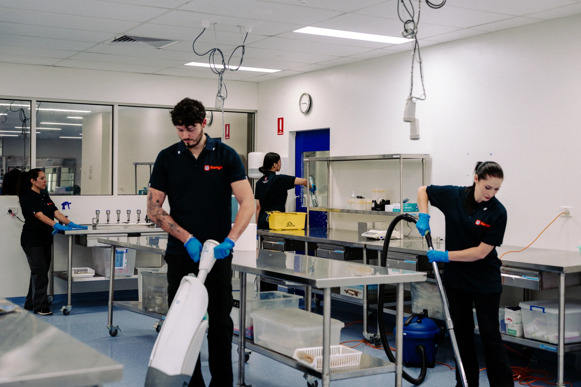 Kango staff cleaning floors and benches in a preparation room