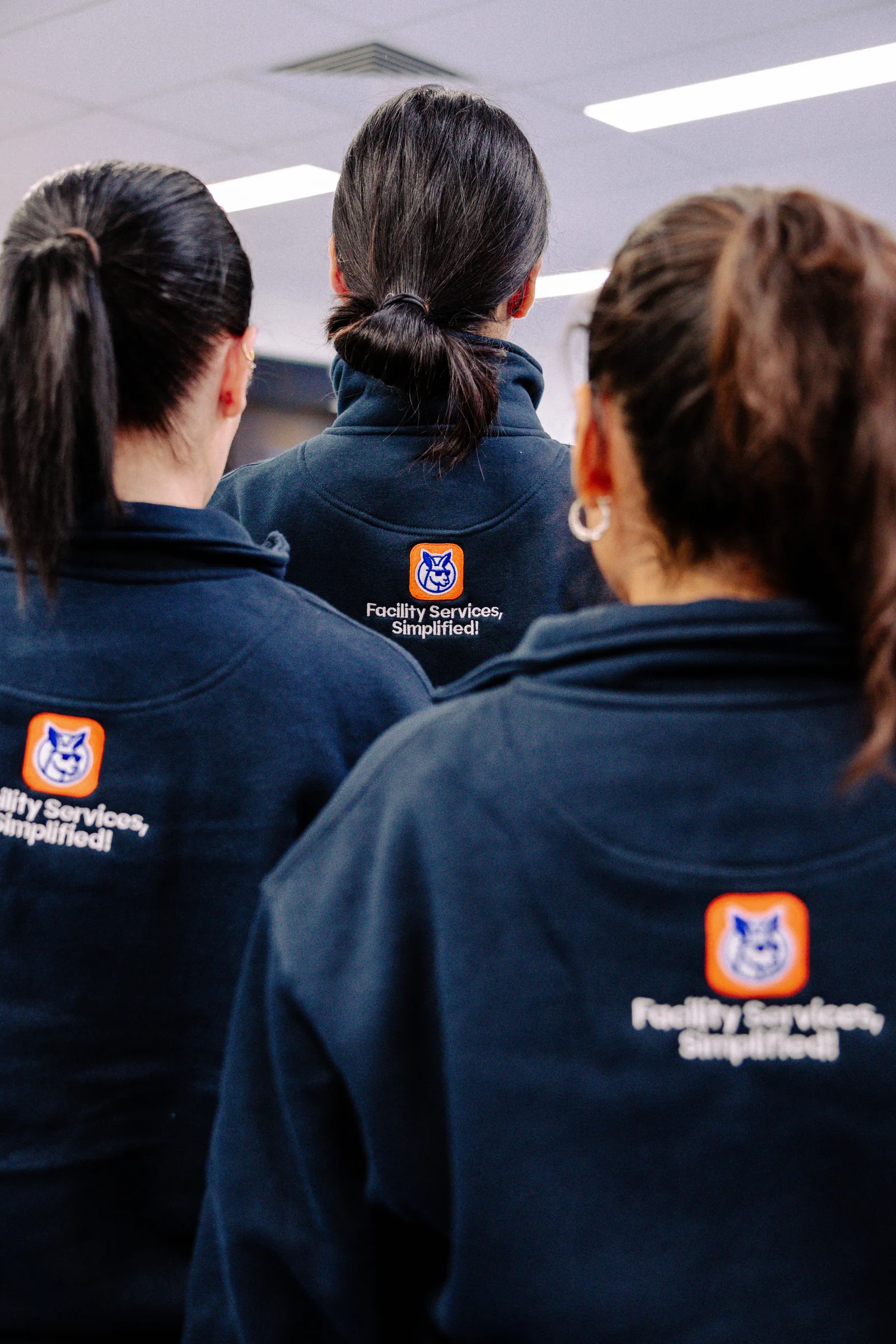 Kango staff walking through a corridor in branded workwear