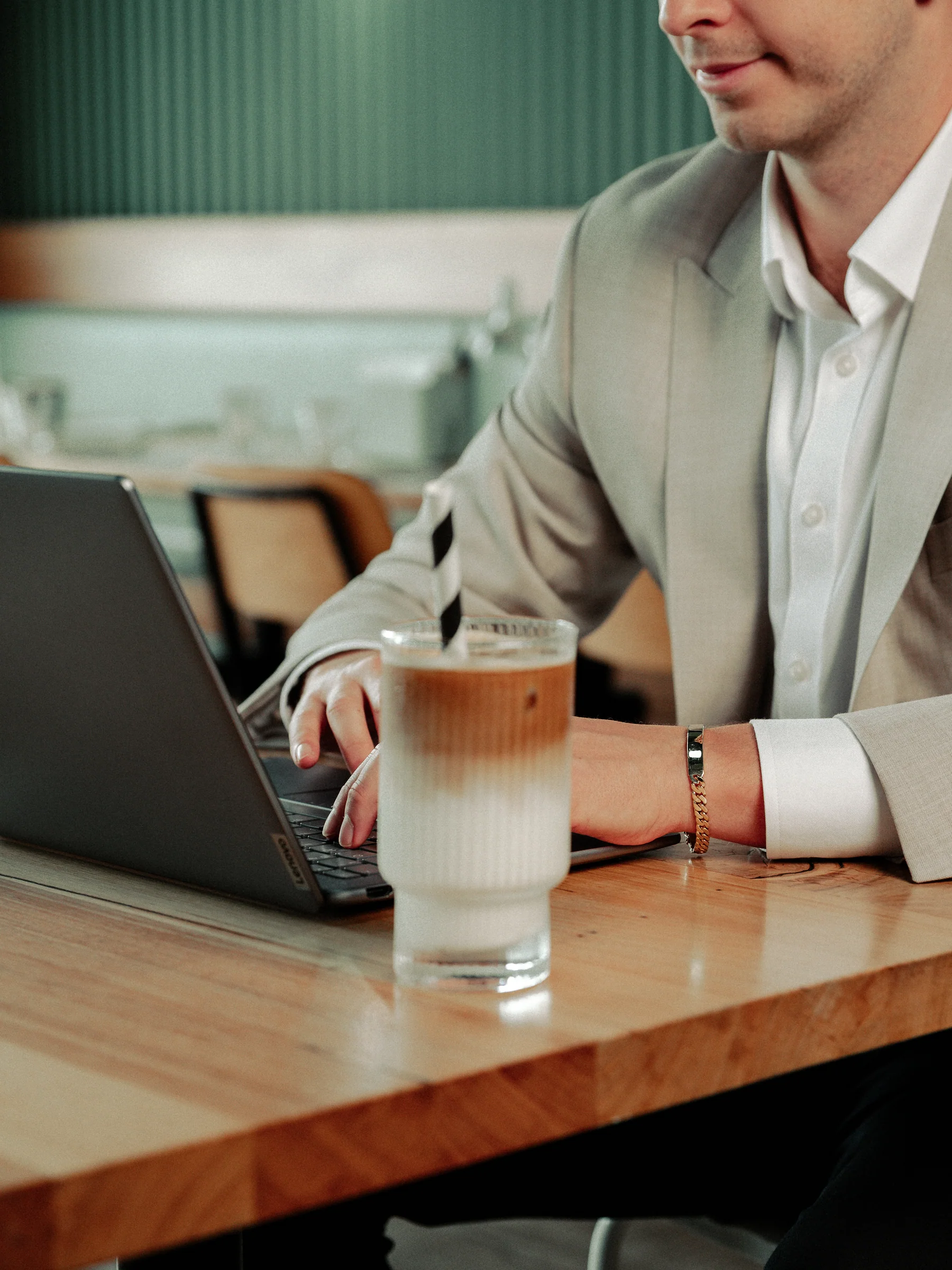 Michael working on a laptop beside an iced coffee