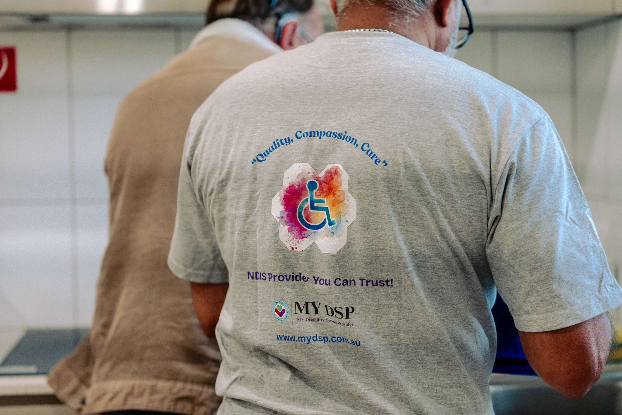 A grey MyDSP-branded shirt photographed from behind in a kitchen