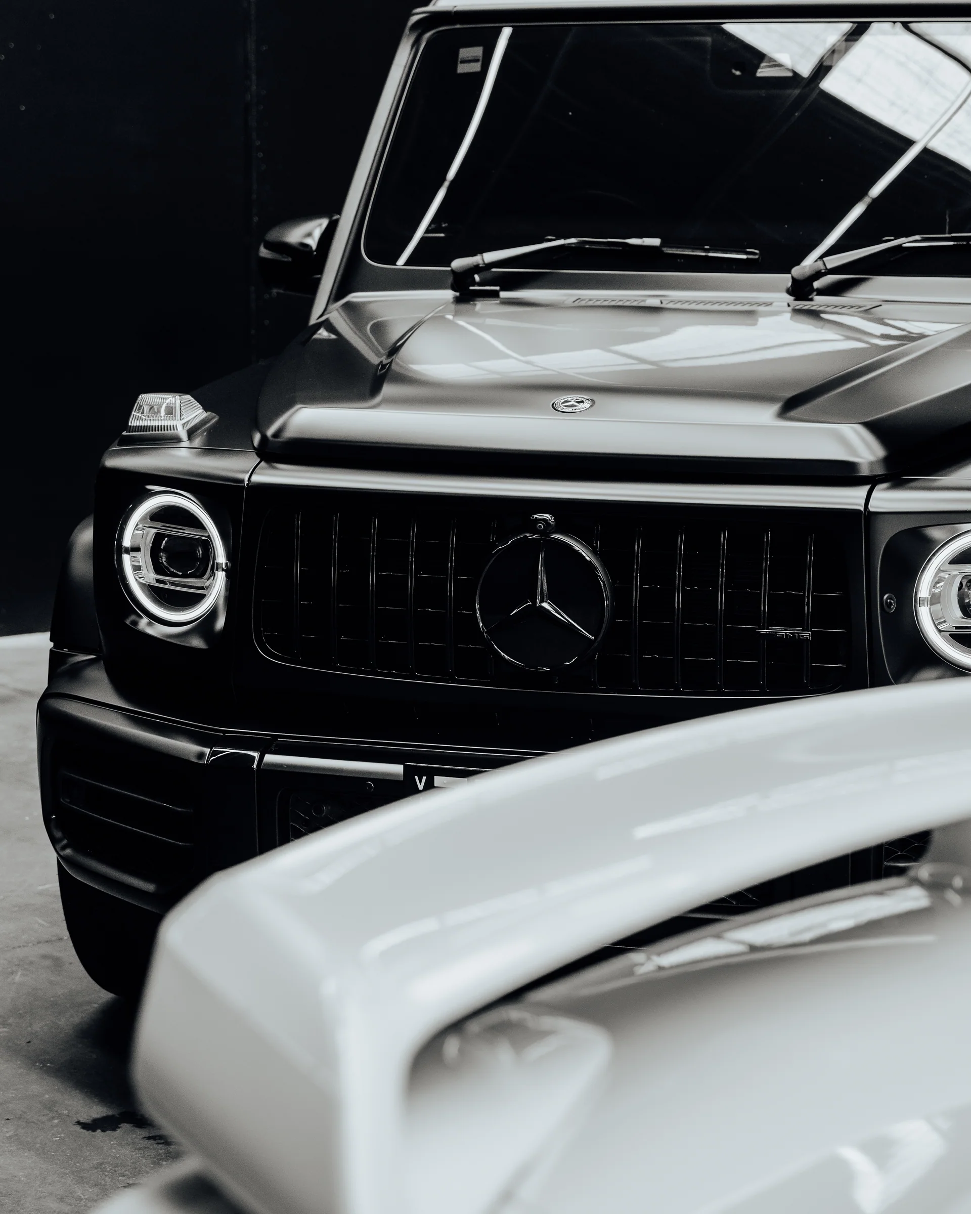 Close view of a dark vehicle grille and finished exterior at Xotic Customs