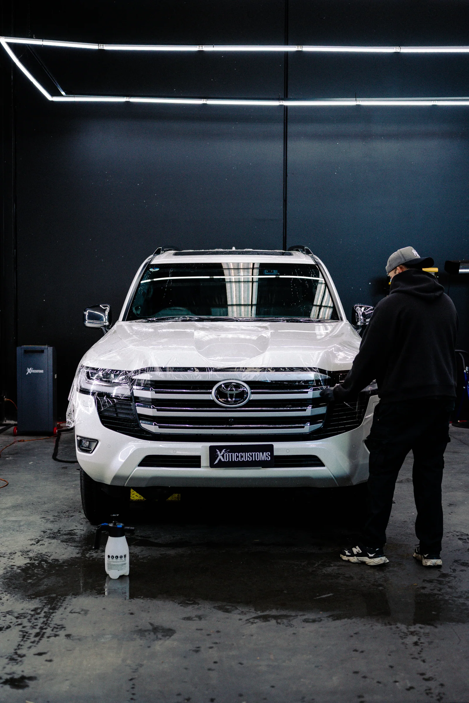 A white four-wheel drive being worked on inside the Xotic Customs workshop